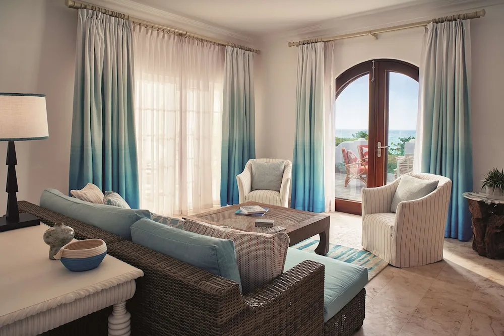 Suite living room with terrace doors and blue curtains at La Samanna, St Martin.