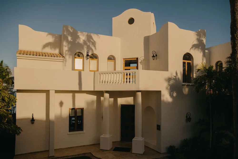 Cream villa exterior with balcony, arched windows and columns at La Samanna, St Martin.