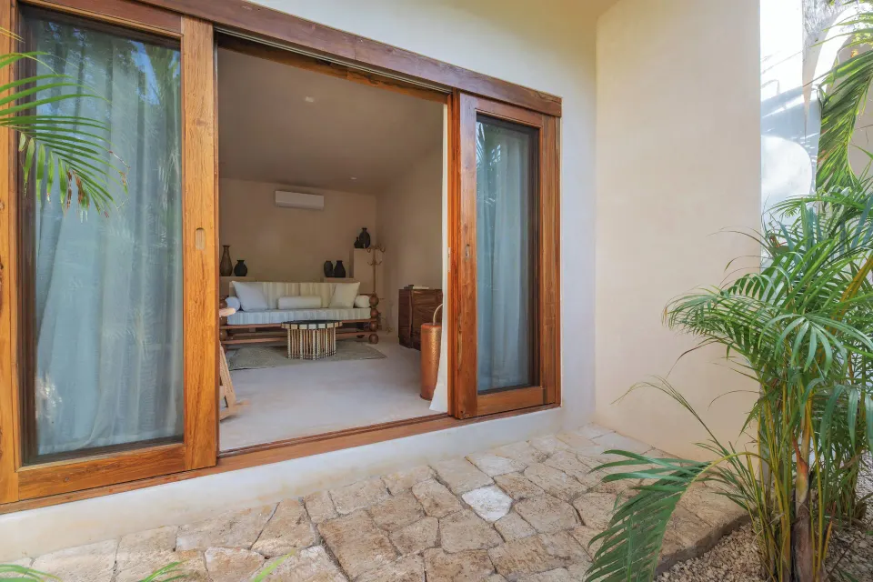 Sliding glass doors opening onto a small stone courtyard at La Valise Tulum.