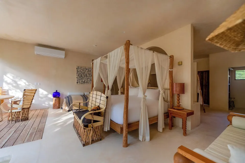 Canopy king bed and seating area inside a Junior Suite at La Valise Tulum.