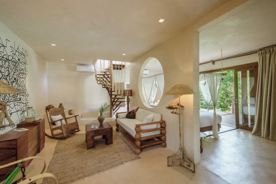 Sitting area with spiral staircase and bedroom beyond in a Junior Suite at La Valise Tulum.