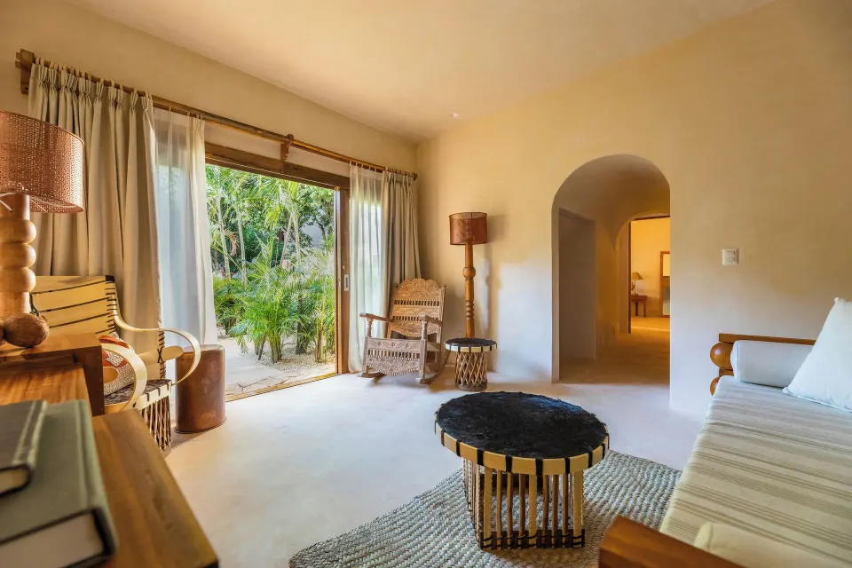 Bright living area with sliding doors opening to lush garden at La Valise Tulum.