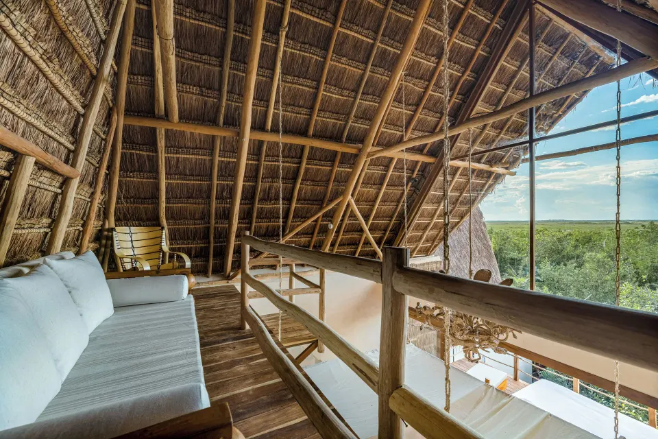 Thatched loft seating area overlooking the treetops at La Valise Tulum.