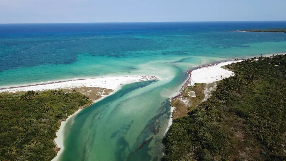 Aerial view of sandy spit and turquoise ocean inlet at La Valise Tulum