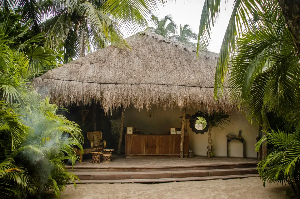 Thatched-roof open-air reception pavilion surrounded by foliage at La Valise Tulum.