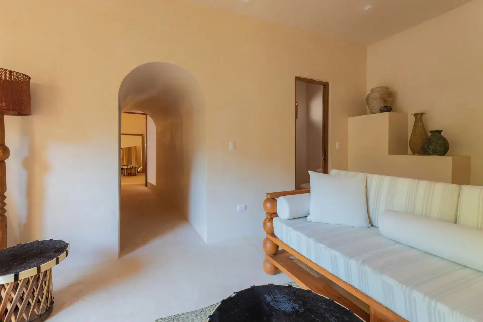Sofa and arched hallway in a softly lit room at La Valise Tulum.