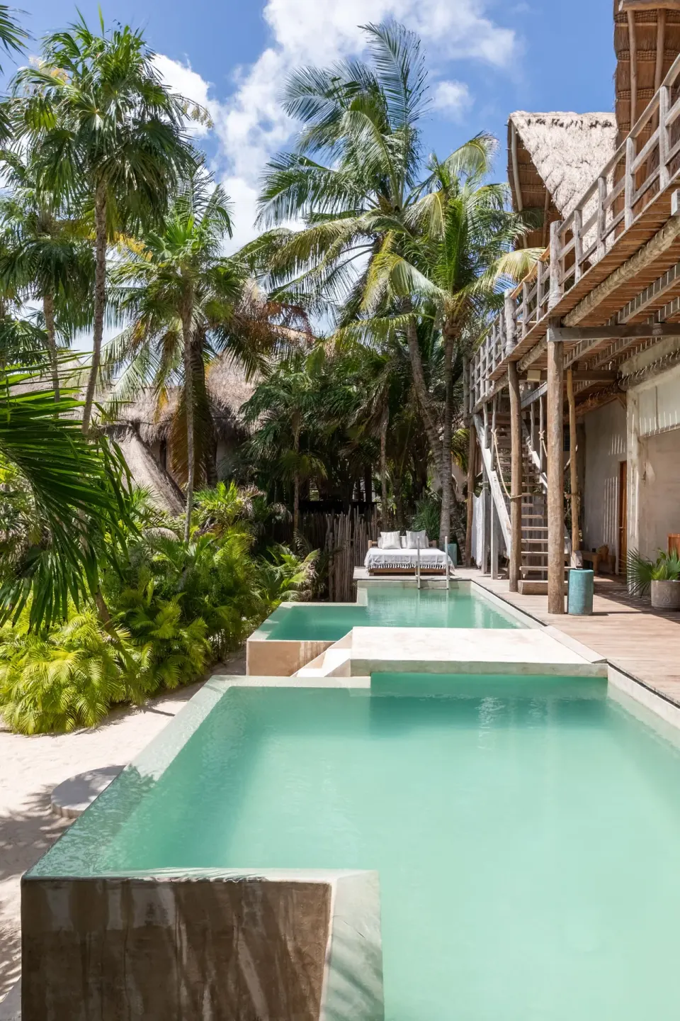 Tiered private plunge pools surrounded by lush palms at La Valise Tulum.