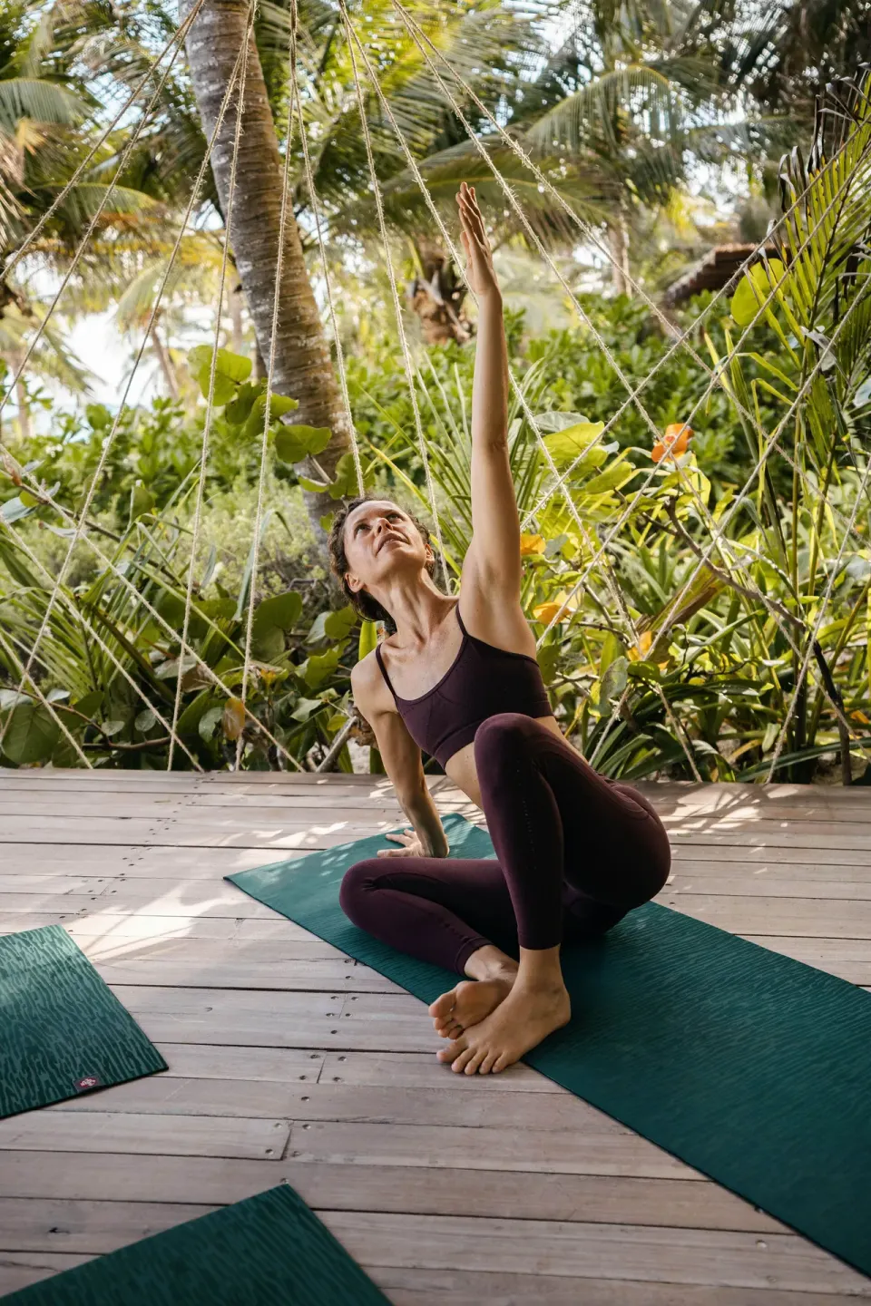 Guest practicing yoga on a sheltered deck surrounded by greenery at La Valise Tulum