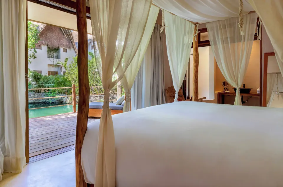Four-poster king bed with sheer curtains in Cenote Suite Lower at La Valise Tulum