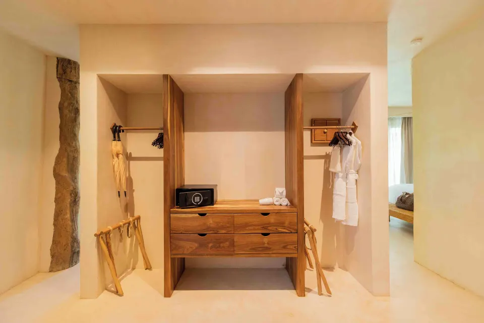 Open closet area with wooden drawers, safe and robes in Garden Suite Lower at La Valise Tulum