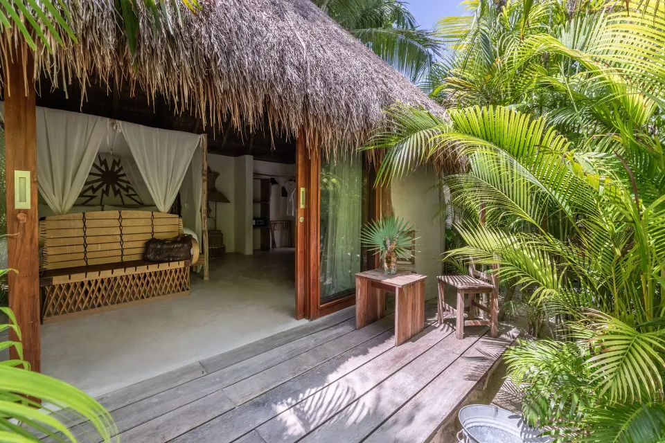 Garden View Room open to a wooden deck and lush tropical plants at La Valise Tulum.