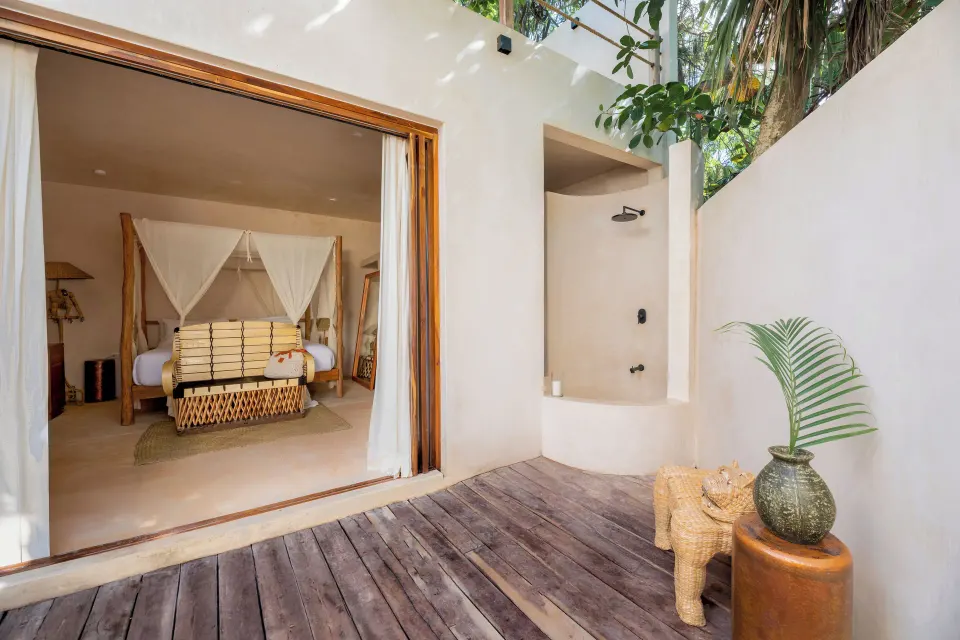 Outdoor wooden deck with an open-air shower next to the Jungle View Room at La Valise Tulum.