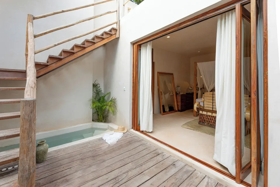 Sliding doors open from the Jungle View Room onto a wooden deck with a small plunge pool and stairs up to a rooftop at La Val