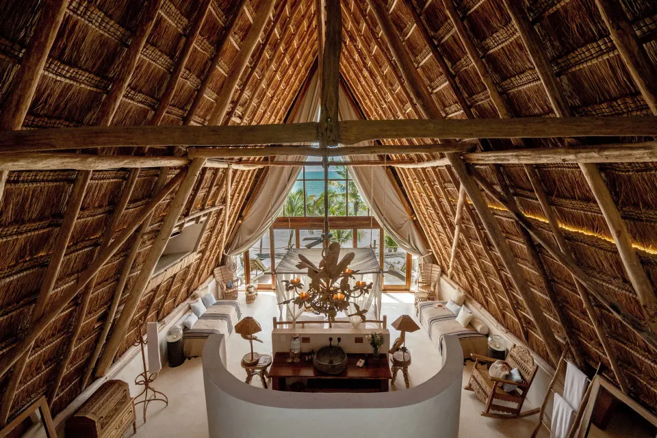 Overhead view of the master suite's vaulted thatched ceiling and seating area with ocean view at La Valise Tulum.