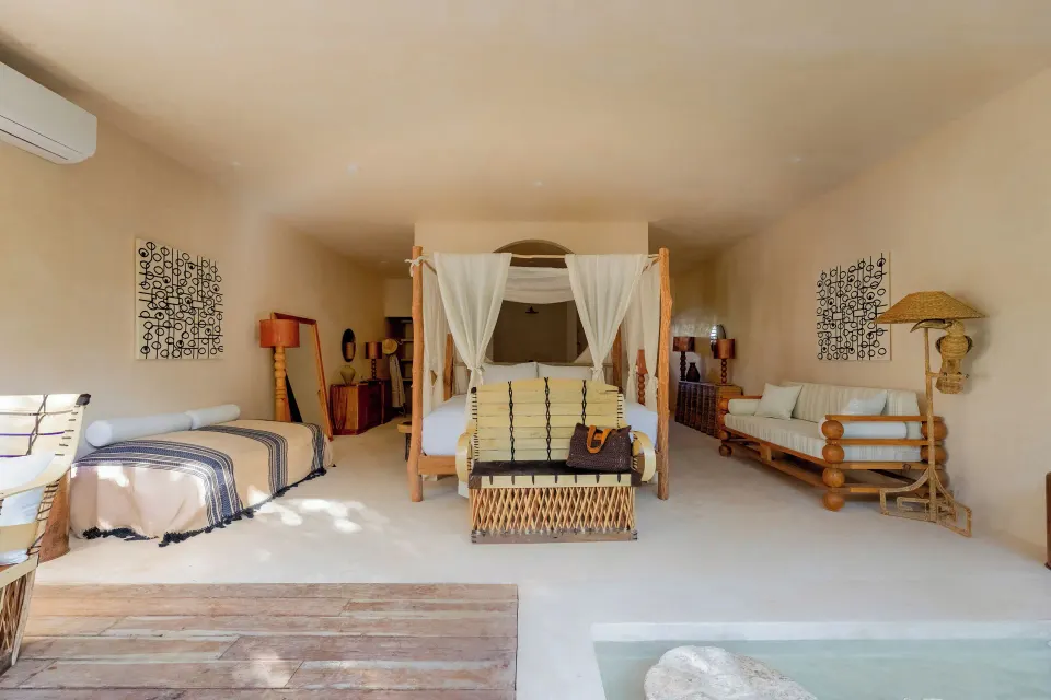 Front-facing view of canopy bed flanked by daybed and sofa in Signature Suite at La Valise Tulum