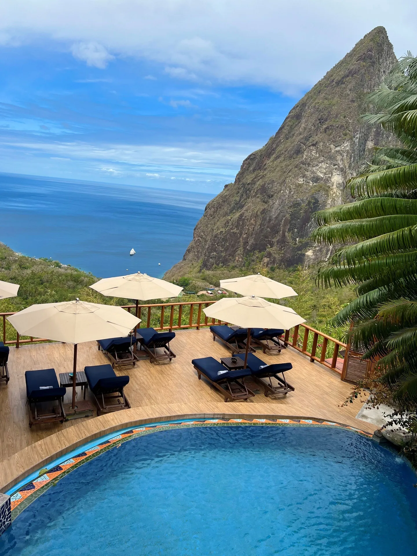 Pool deck with loungers and umbrellas overlooking the Piton and sea at Ladera Resort.