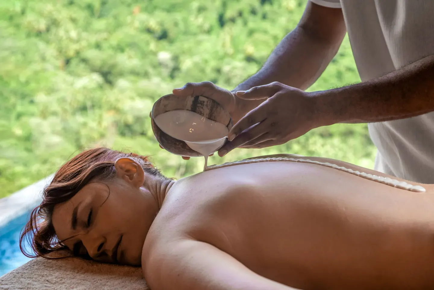 A spa treatment pours liquid along a guest’s back at Ladera Resort.