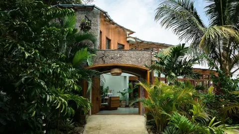 Stone and wood resort building framed by tropical plants at Ladera Resort.