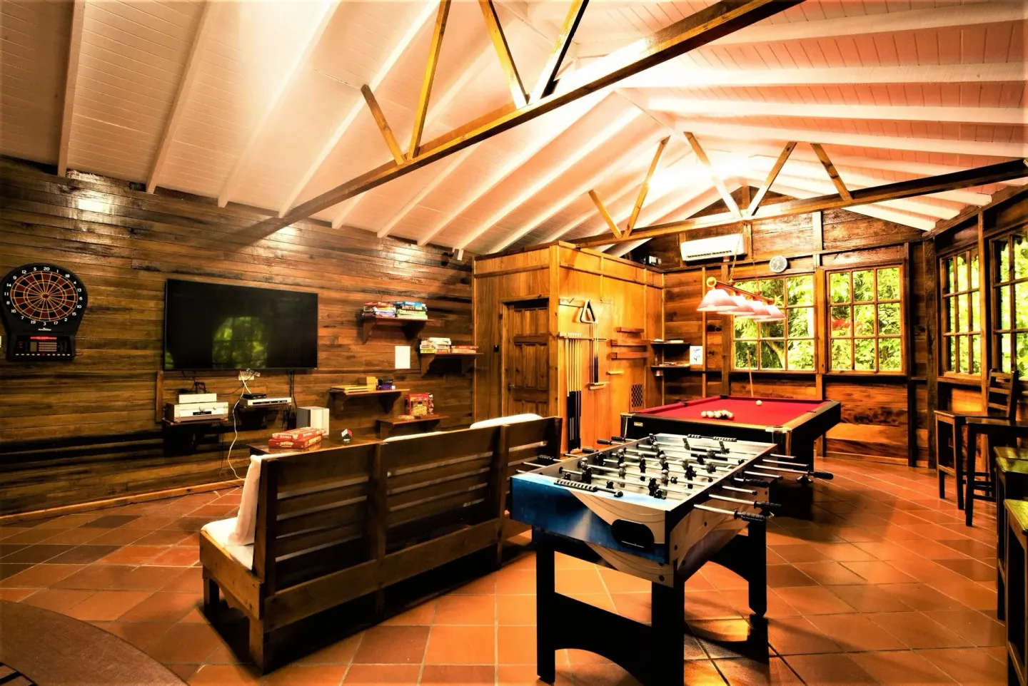 Wood-paneled games room with foosball, pool table, and TV at Ladera Resort.