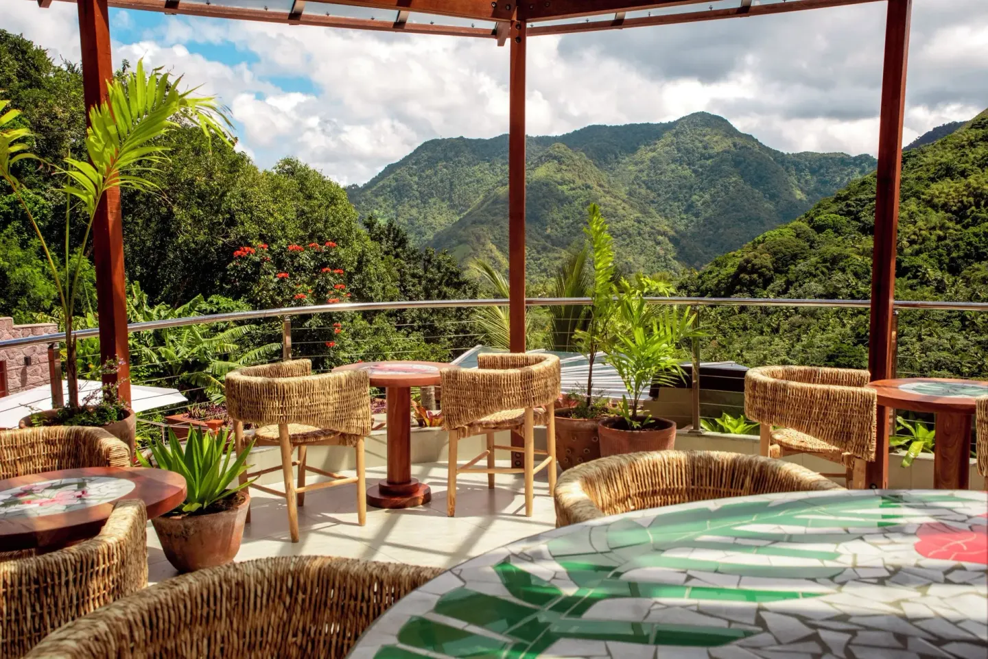 A terrace with wicker chairs, mosaic tables, and mountain views at Ladera Resort.