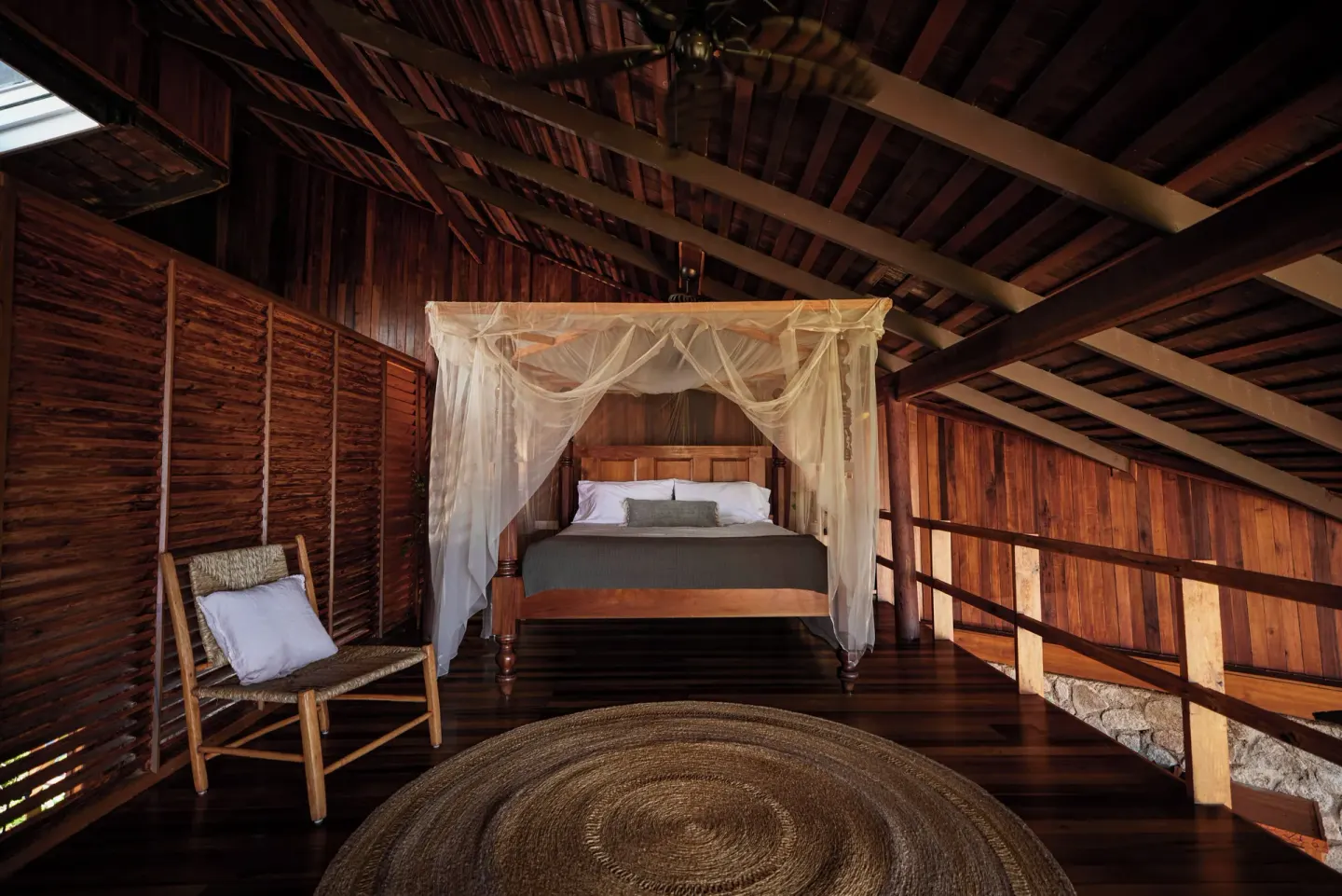 Heritage Suite canopy bed under a timber roof at Ladera Resort.