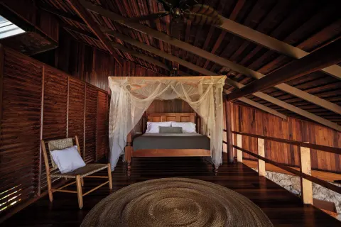 Heritage Suite canopy bed under a timber roof at Ladera Resort.