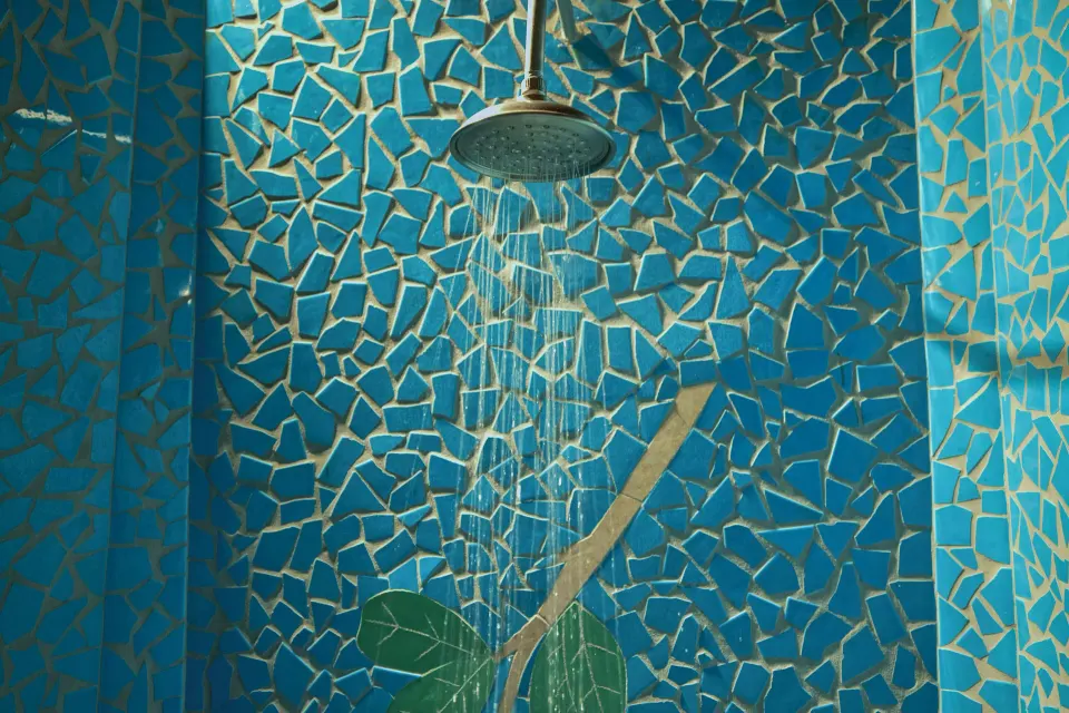 Blue mosaic shower with water running in the Hilltop Dream Suite at Ladera Resort.