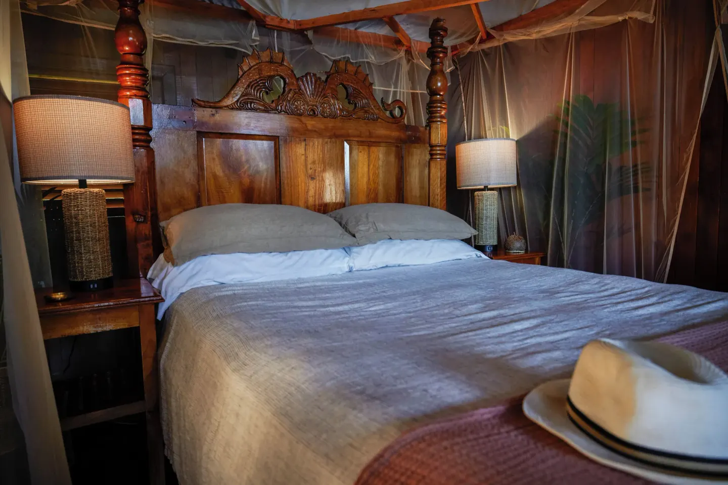 Petit Piton Suite canopy bed with bedside lamps at Ladera Resort.