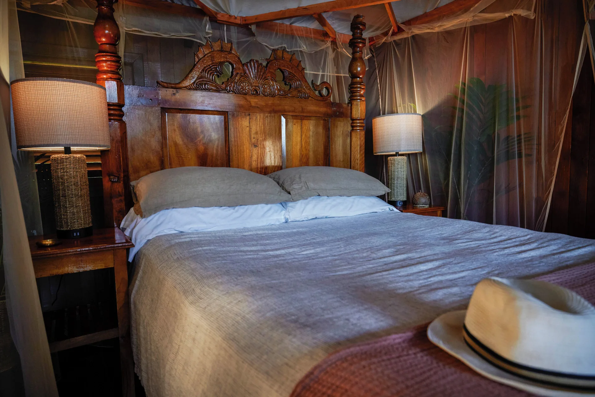 Petit Piton Suite canopy bed with bedside lamps at Ladera Resort.