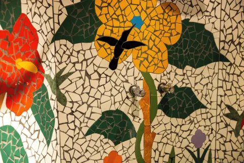 Rainbow Suite mosaic shower wall with flower and hummingbird design at Ladera Resort.
