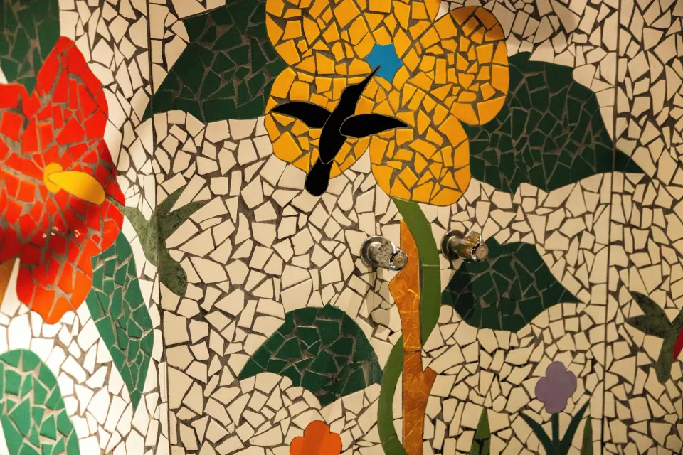 Rainbow Suite mosaic shower wall with flower and hummingbird design at Ladera Resort.
