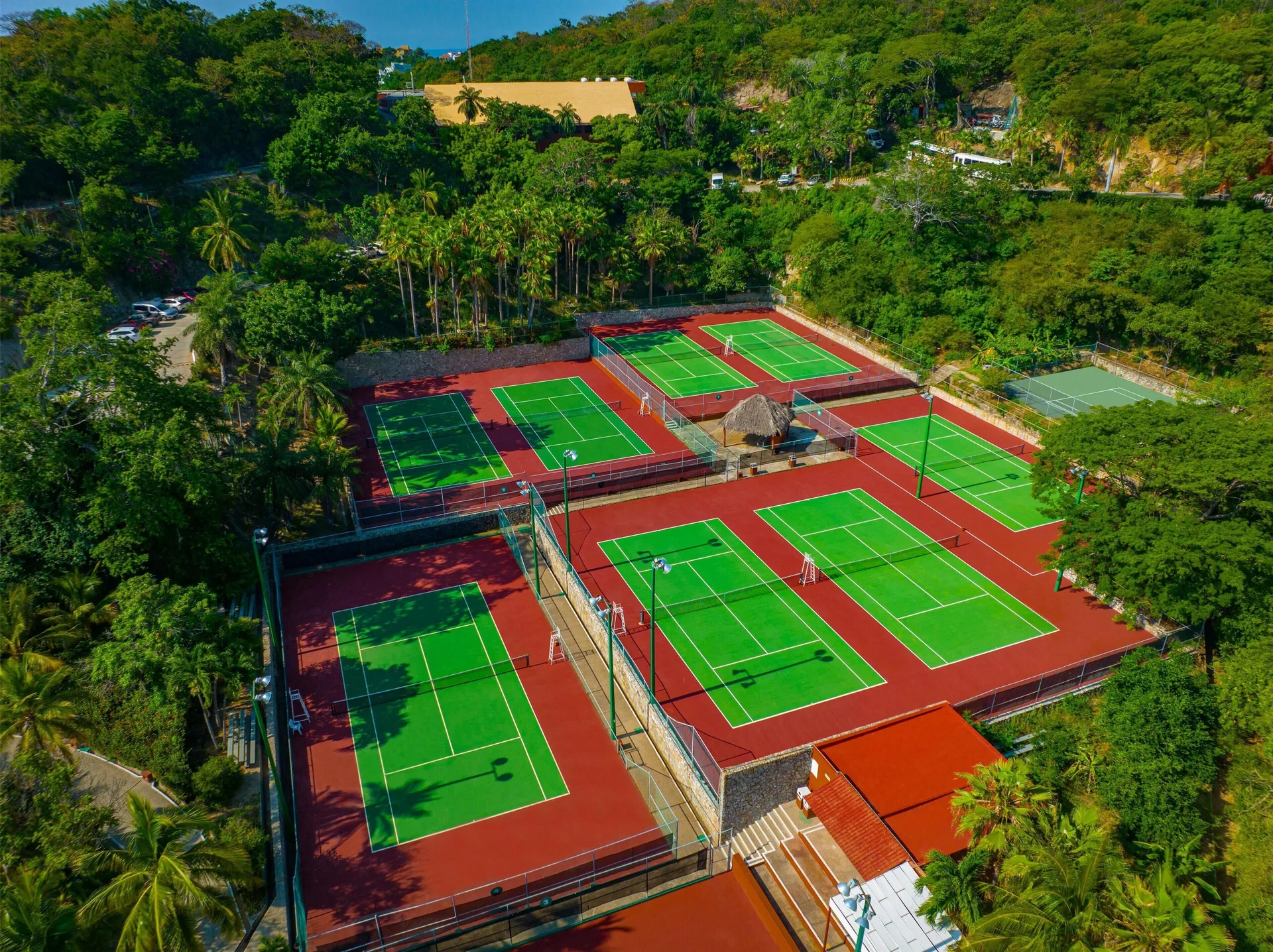Aerial view of tennis courts surrounded by trees at Las Brisas Huatulco.
