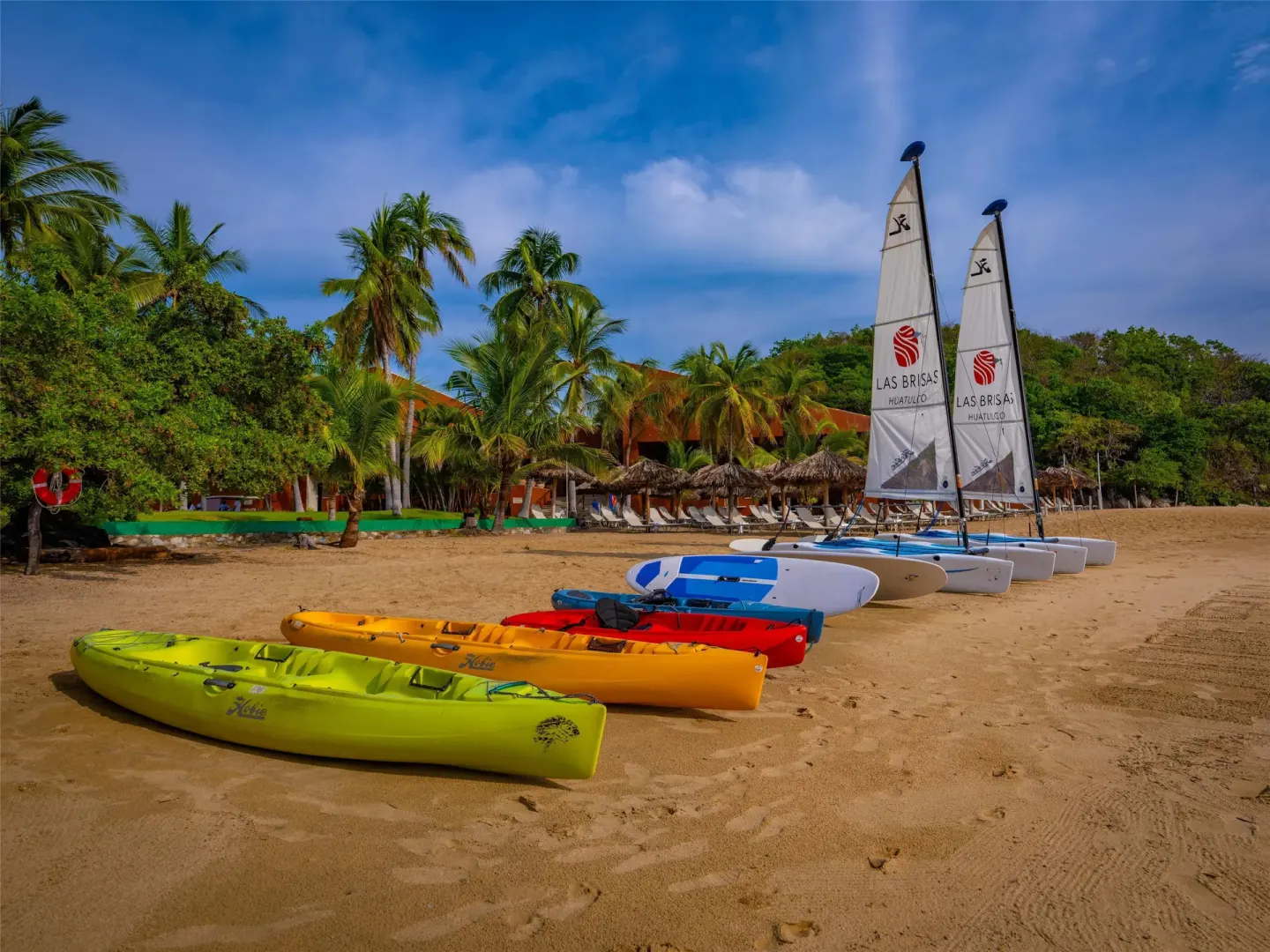 Colorful kayaks and sailboats line the sandy beach at Las Brisas Huatulco.
