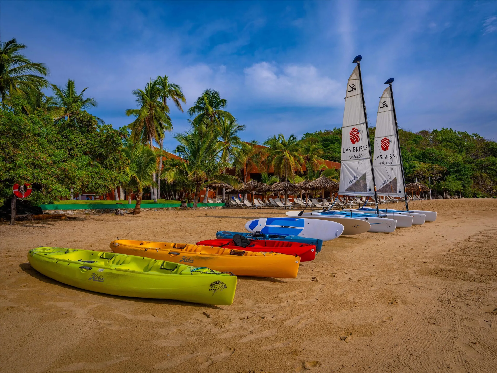 Colorful kayaks and sailboats line the sandy beach at Las Brisas Huatulco.