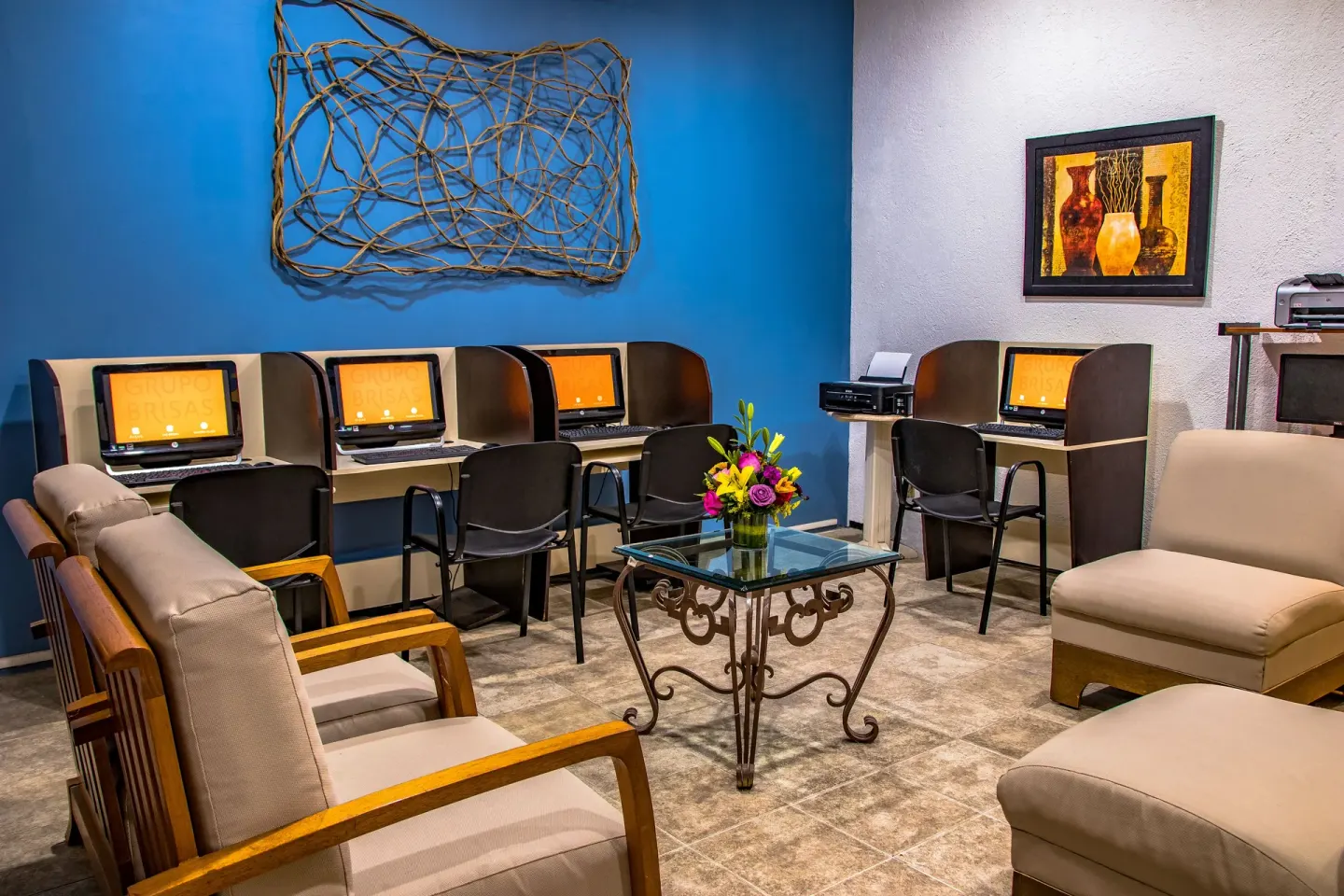Business center lounge with computer stations and seating at Las Brisas Huatulco.