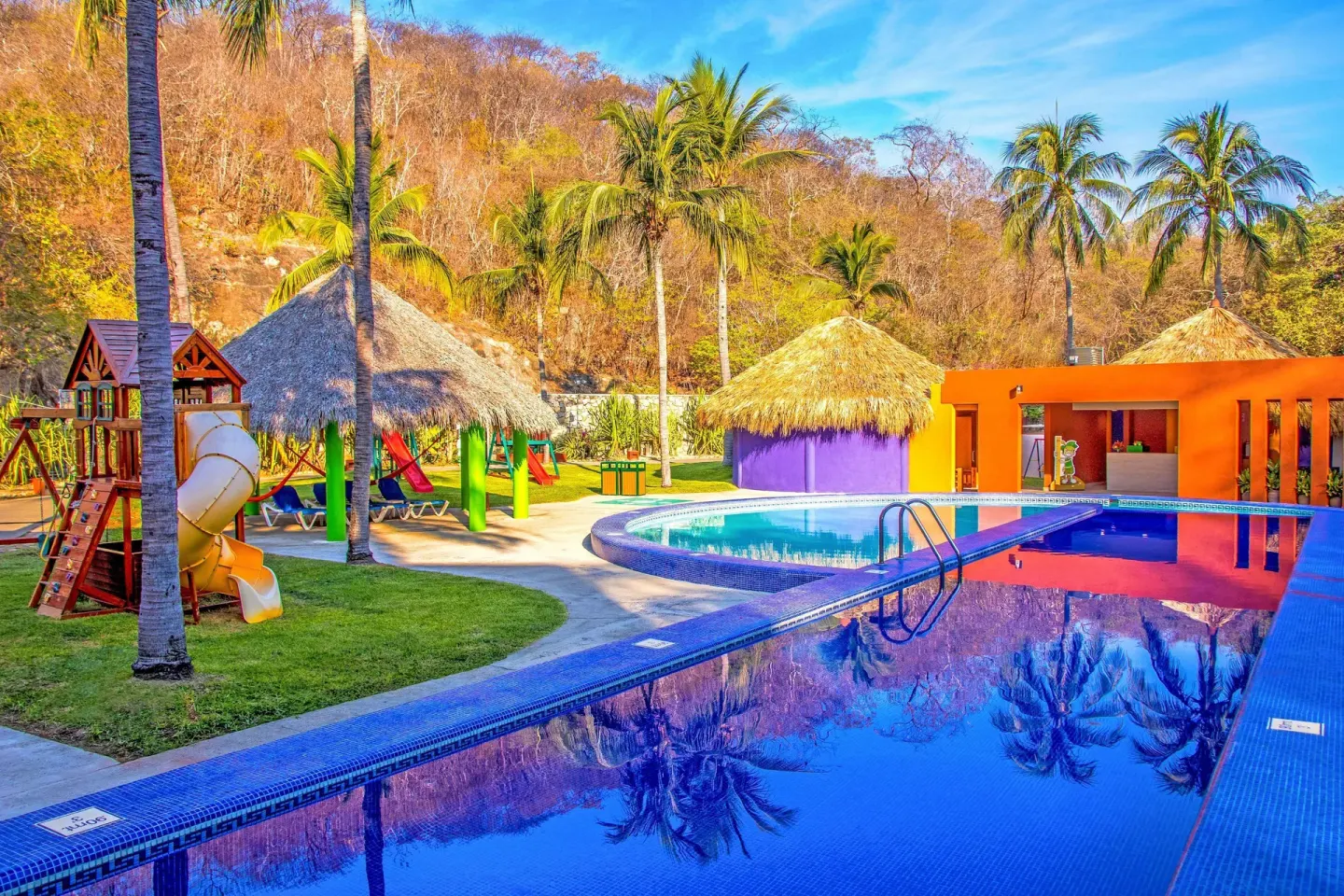 Family pool with playground and palapa shade at Las Brisas Huatulco.