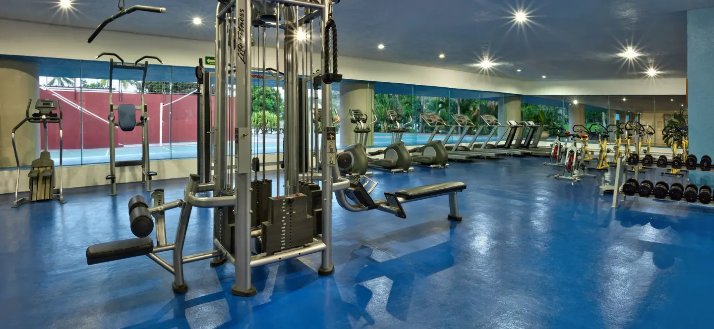 Fitness center with treadmills, weight machines, bikes and dumbbells at Las Brisas Huatulco.