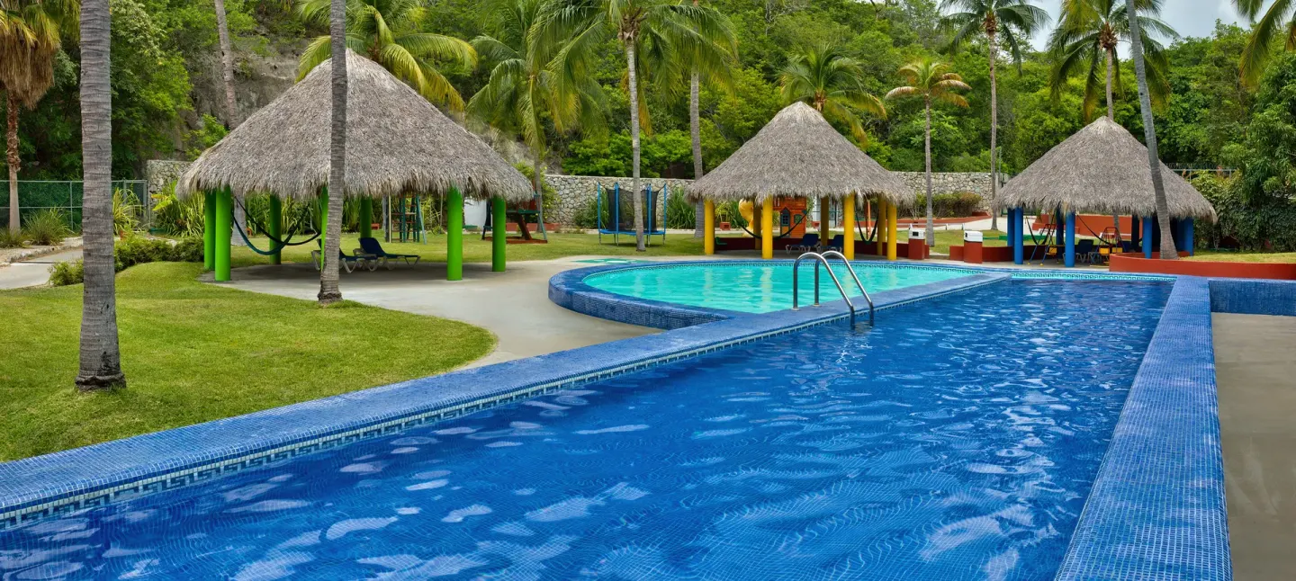 Pool channels, palapas, lawns and palms at Las Brisas Huatulco.