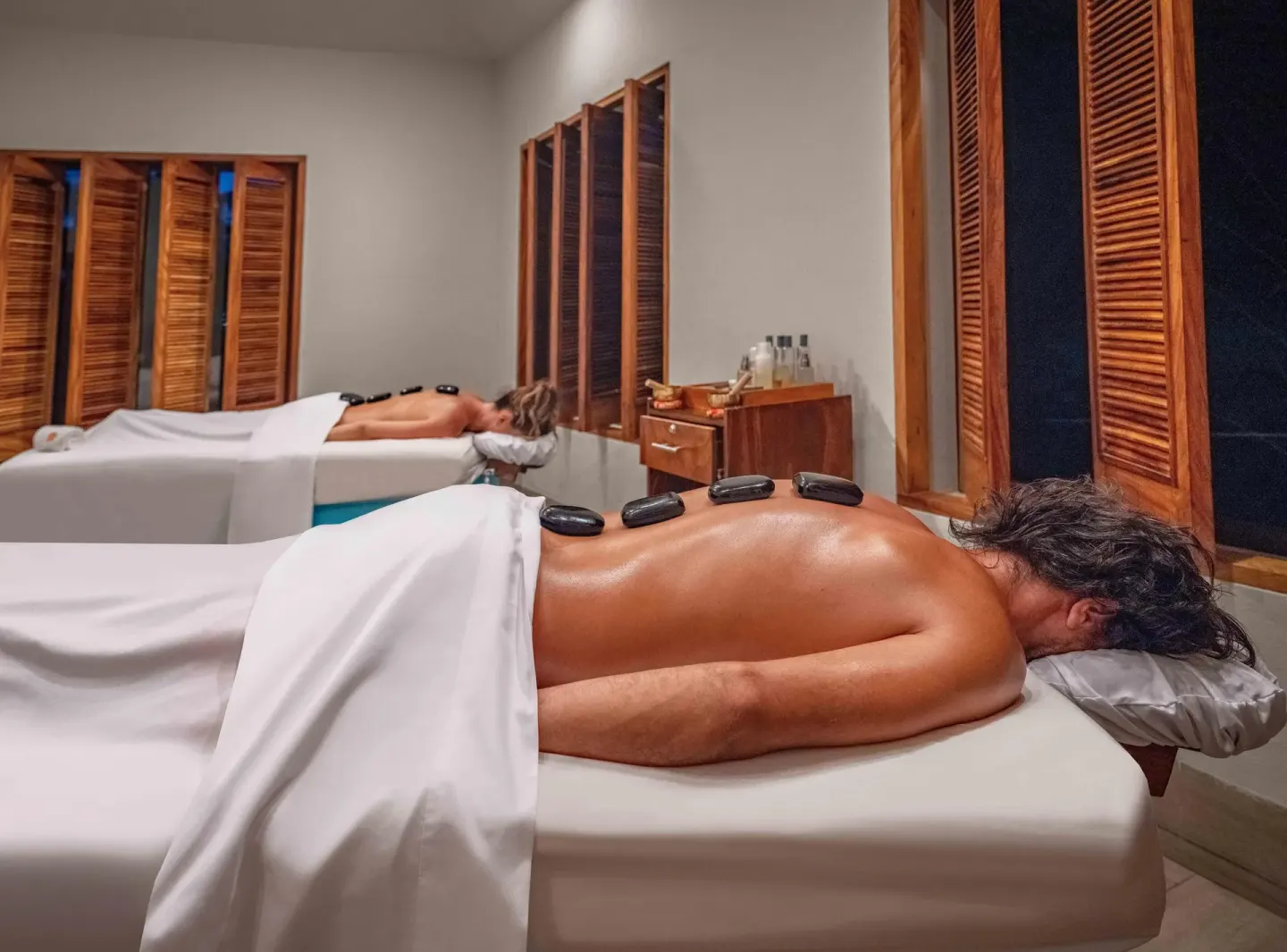 Guests receive hot stone massages in a spa room at Las Brisas Huatulco.