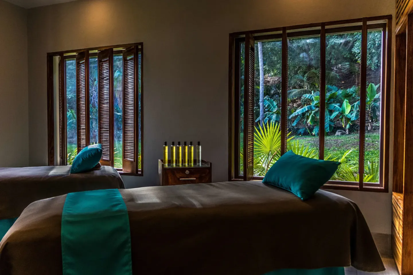 Two spa treatment beds face garden windows at Las Brisas Huatulco.