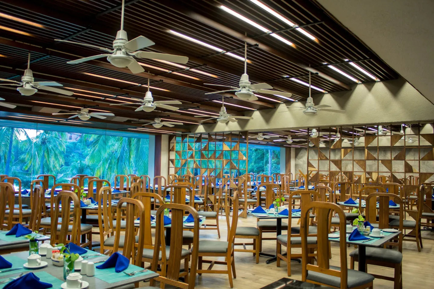 Buffet-style dining room with blue napkins and garden windows at Las Brisas Huatulco.