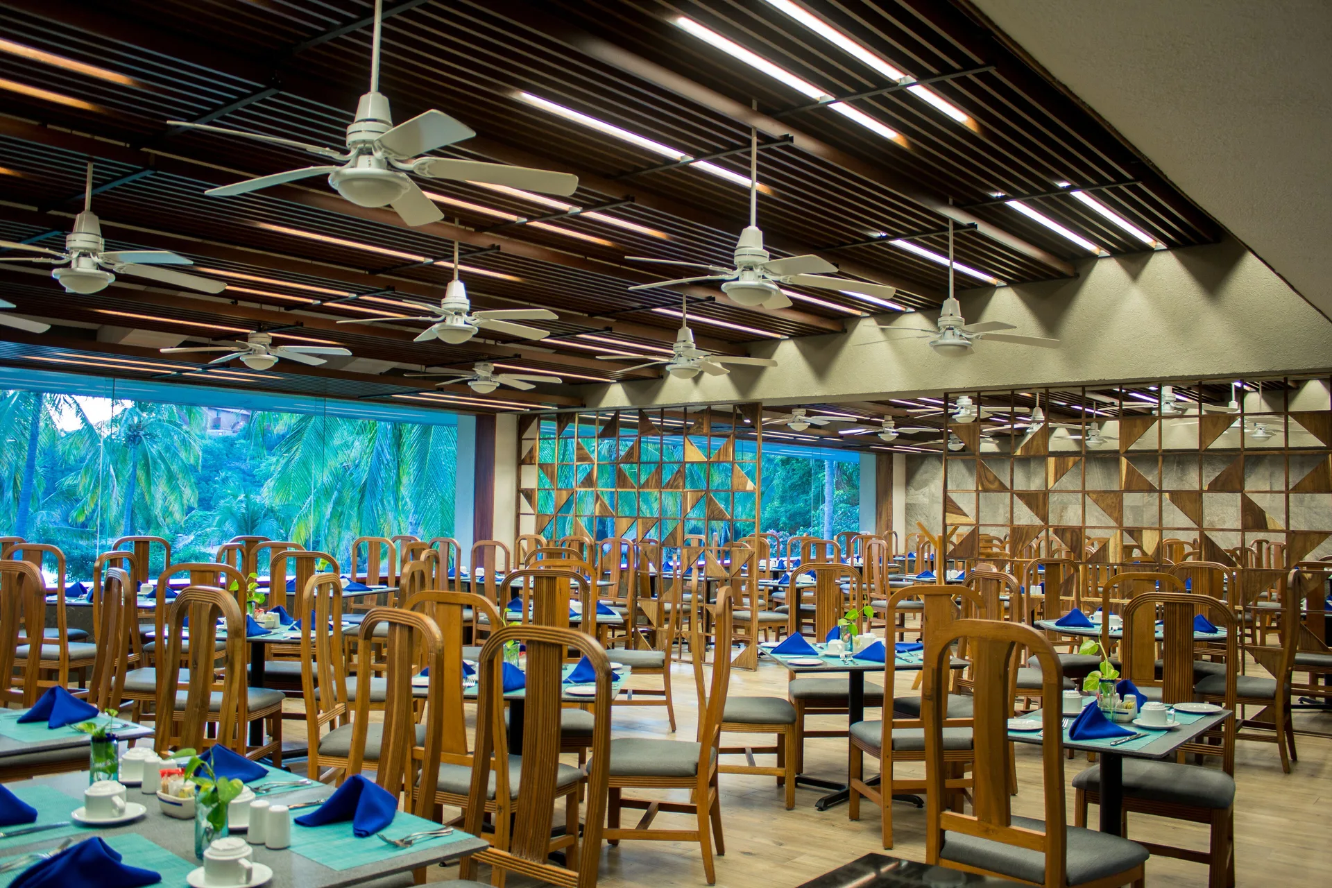 Buffet-style dining room with blue napkins and garden windows at Las Brisas Huatulco.