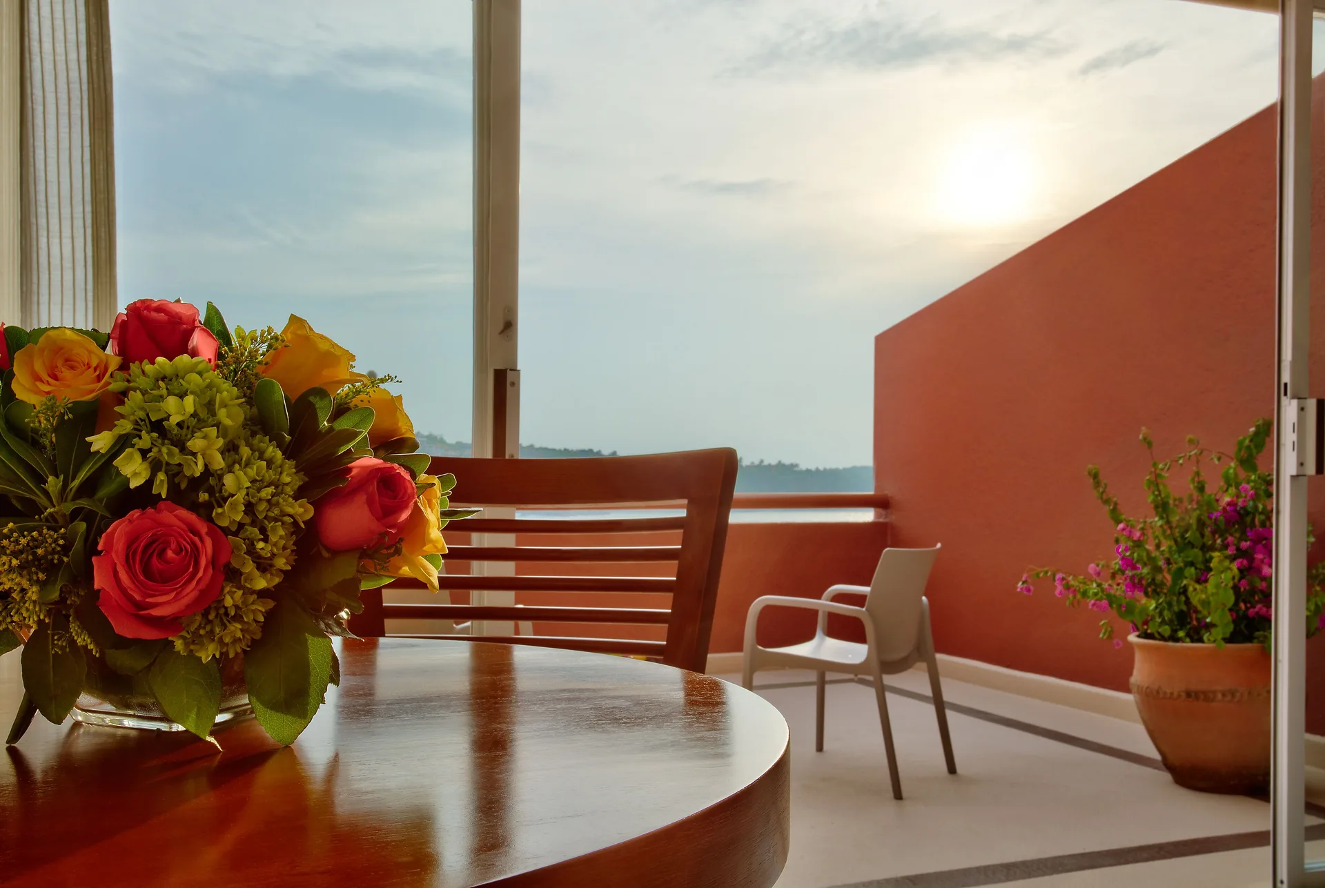 Balcony seating with flowers and ocean view at Las Brisas Huatulco.