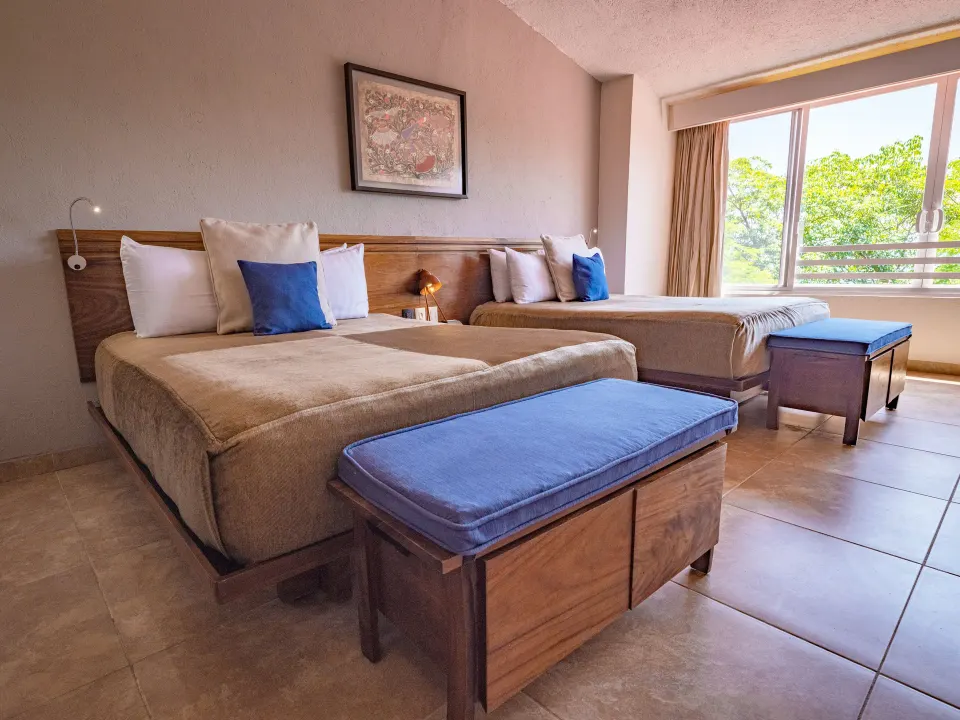 Deluxe Room with two beds beside a wide window at Las Brisas Huatulco.