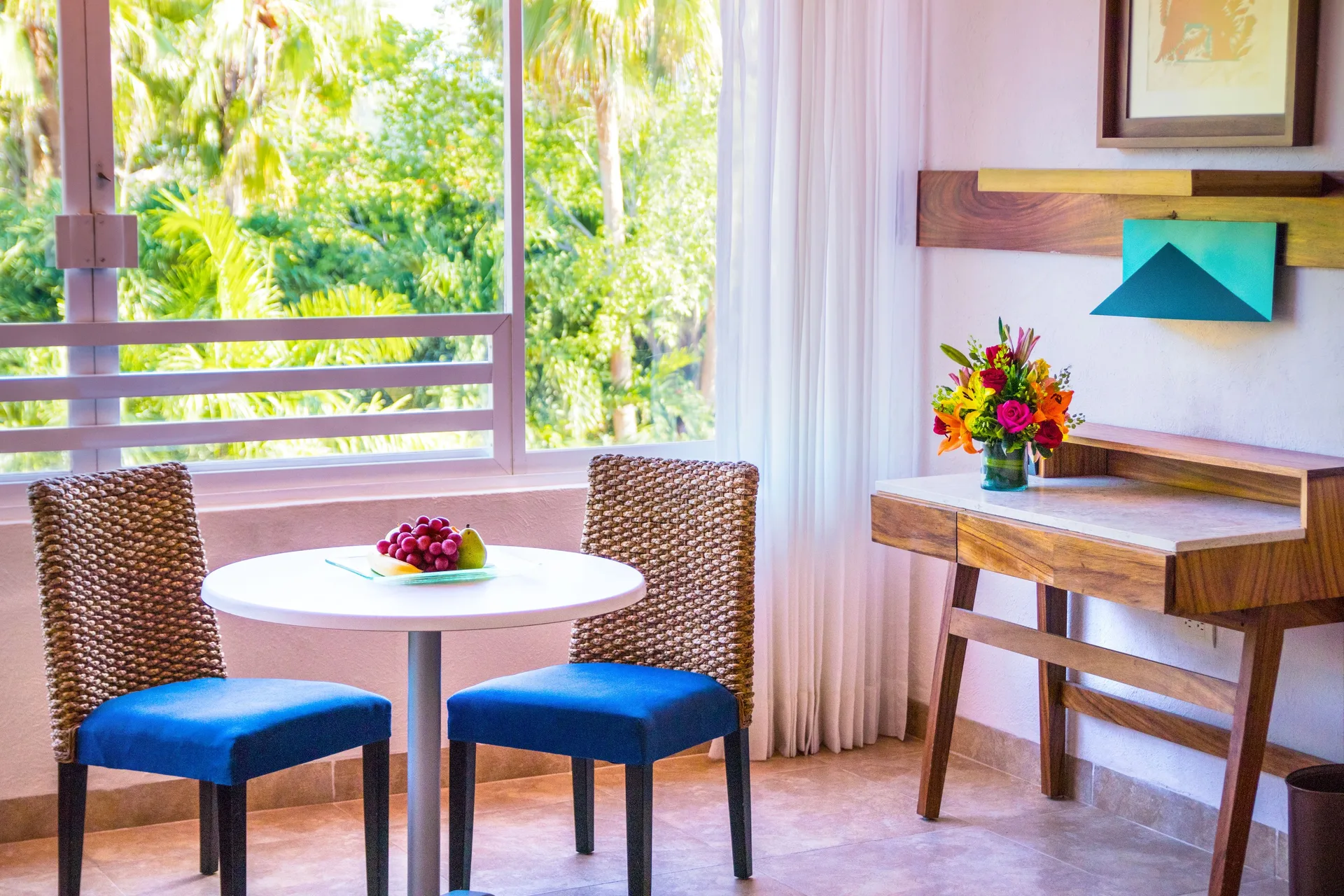 Deluxe Room table, chairs, and desk by the window at Las Brisas Huatulco.