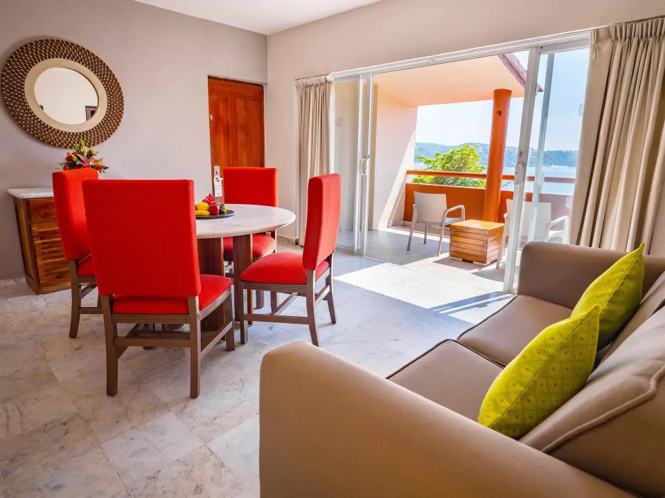 Junior Suite dining and seating area opening to a balcony at Las Brisas Huatulco.
