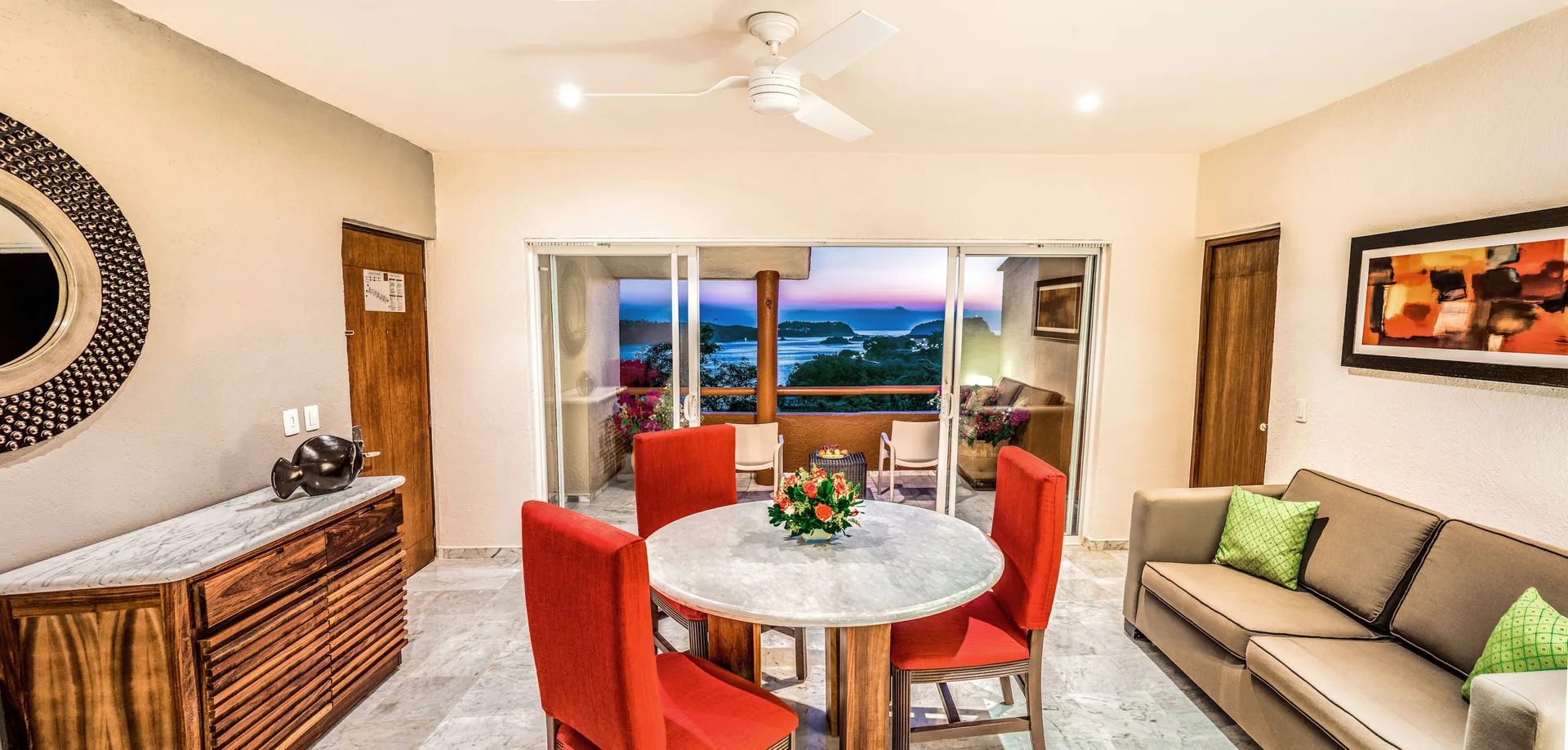 Junior Suite living and dining area with balcony view at Las Brisas Huatulco.