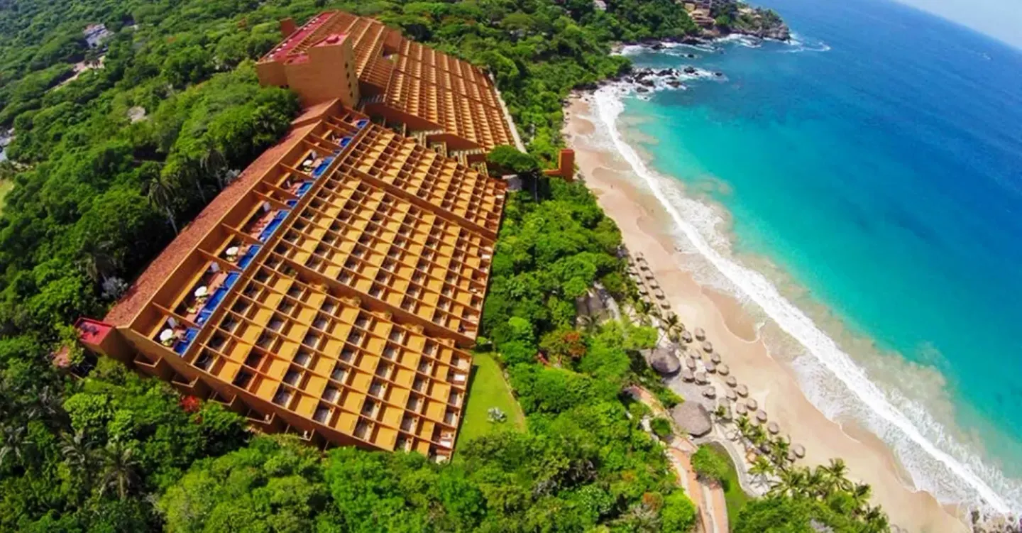Aerial view of Las Brisas Ixtapa beside a sandy beach and turquoise ocean.