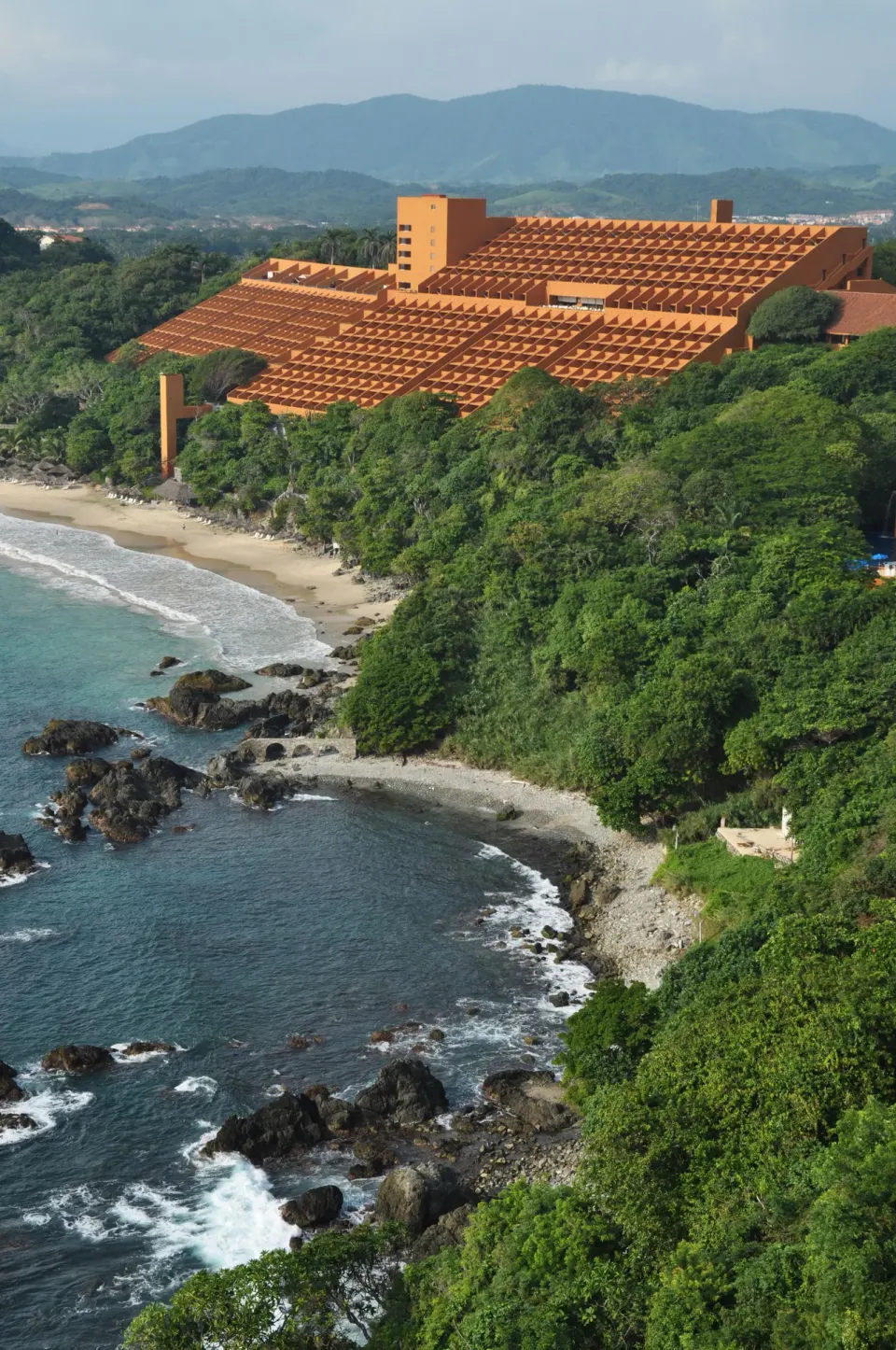 Las Brisas Ixtapa overlooks a rocky cove, beach, and forested coastline.