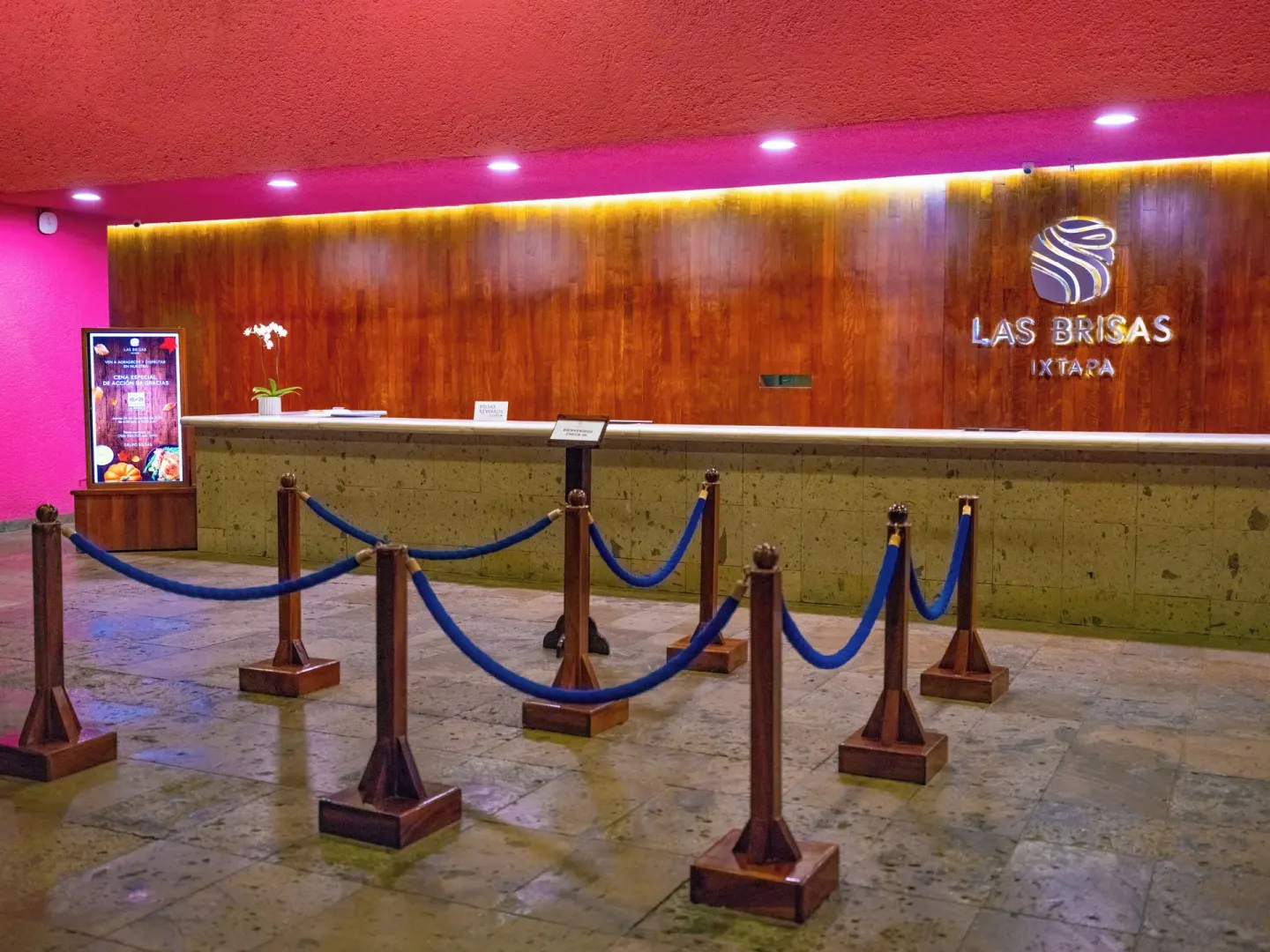 Reception desk with Las Brisas Ixtapa sign on a wood wall behind it.